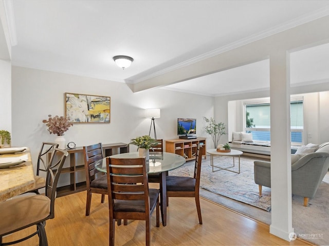 dining area with ornamental molding and light wood-type flooring