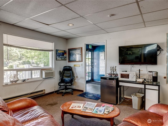 living room featuring a drop ceiling, a baseboard radiator, and carpet flooring