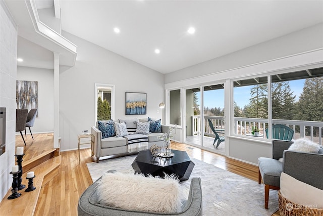 living room with high vaulted ceiling and light wood-type flooring