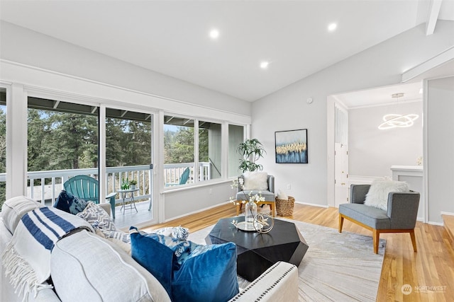 living room featuring hardwood / wood-style flooring, lofted ceiling, and a notable chandelier