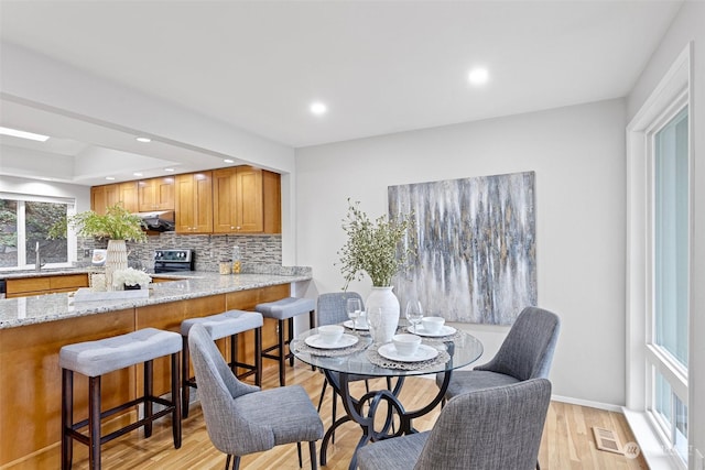 dining area with sink and light wood-type flooring