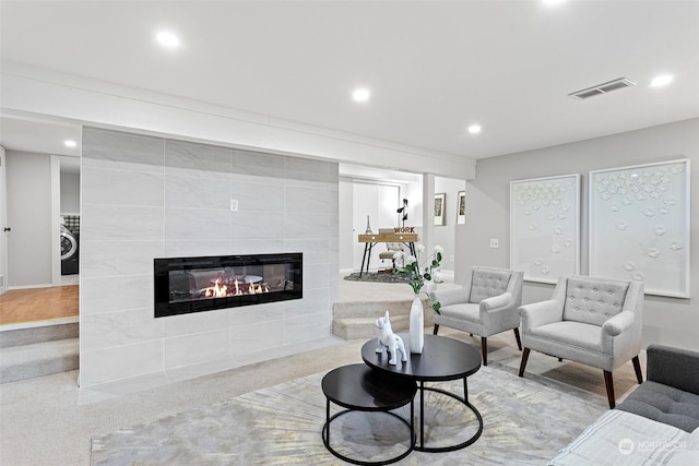 living room featuring washer / clothes dryer and a fireplace