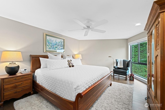 bedroom with wood-type flooring, ceiling fan, and a baseboard radiator