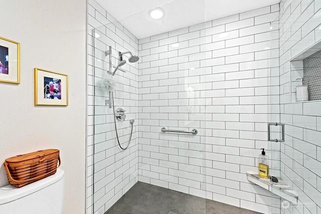 bathroom featuring toilet and a tile shower