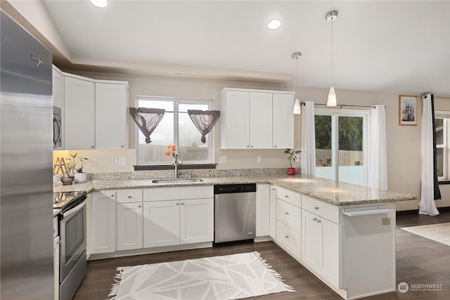 kitchen featuring sink, stainless steel appliances, hanging light fixtures, and white cabinets