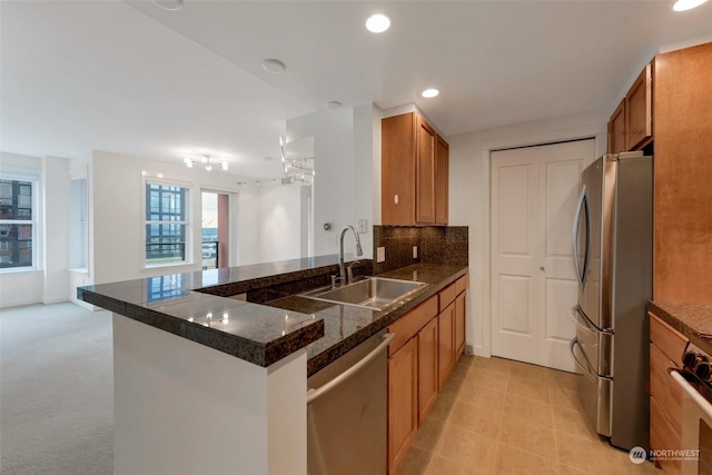 kitchen with light colored carpet, backsplash, kitchen peninsula, sink, and stainless steel appliances