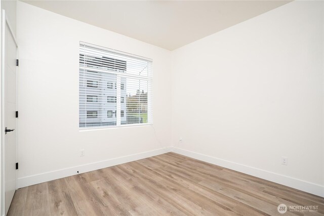 empty room featuring light wood-style floors and baseboards