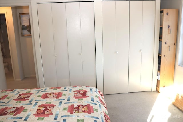 carpeted bedroom featuring two closets