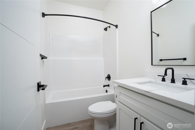 bathroom with toilet, bathtub / shower combination, vanity, and wood finished floors
