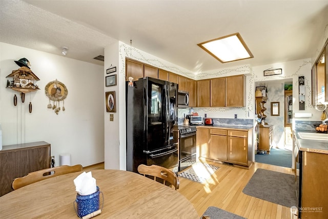 kitchen featuring light hardwood / wood-style flooring and black appliances