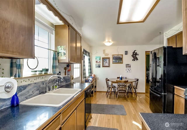 kitchen with sink, light wood-type flooring, and black appliances