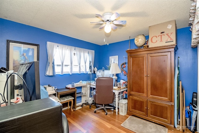 home office with ceiling fan, a textured ceiling, and light wood-type flooring