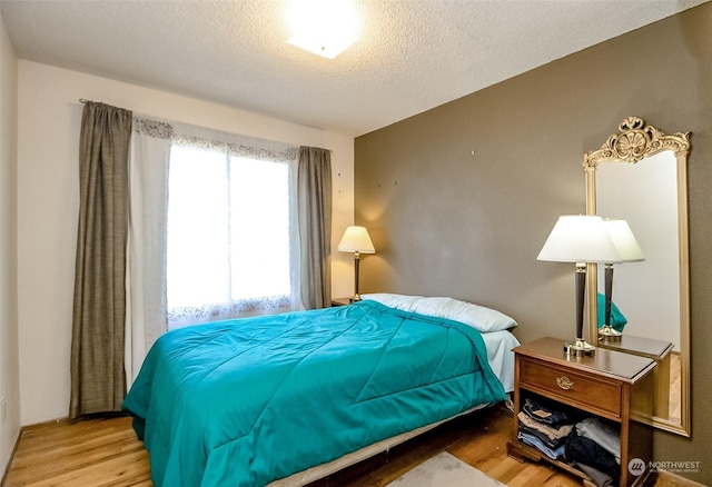 bedroom with wood-type flooring and a textured ceiling