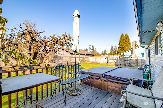 wooden terrace featuring a yard and a covered hot tub