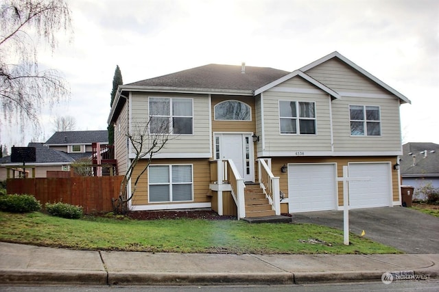 bi-level home with a garage and a front lawn