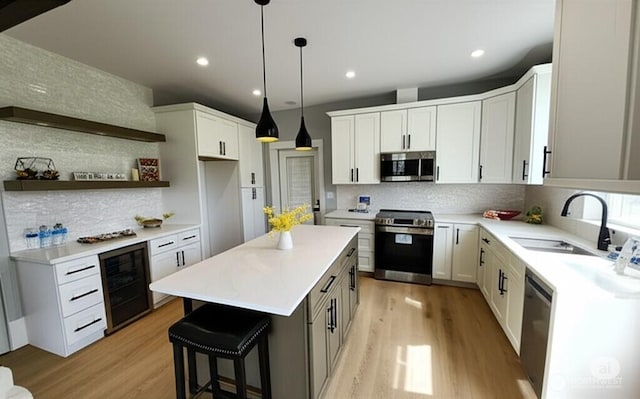 998 Cascade Ave SW, Ocean Shores, WA 98569 - kitchen featuring appliances with stainless steel finishes, wine cooler, a sink, backsplash, and light wood-style flooring