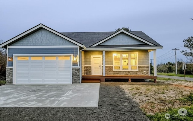 998 Cascade Ave SW, Ocean Shores, WA 98569 - craftsman-style home with stone siding, covered porch, a garage, and concrete driveway