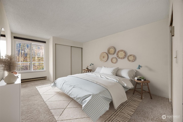 bedroom featuring a baseboard radiator, light colored carpet, a textured ceiling, and a closet