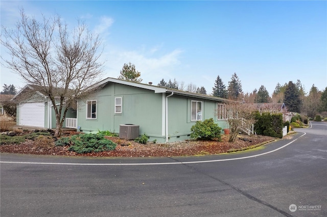 view of property exterior with a garage and central AC