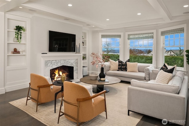 living room featuring built in features, recessed lighting, a fireplace, and wood finished floors