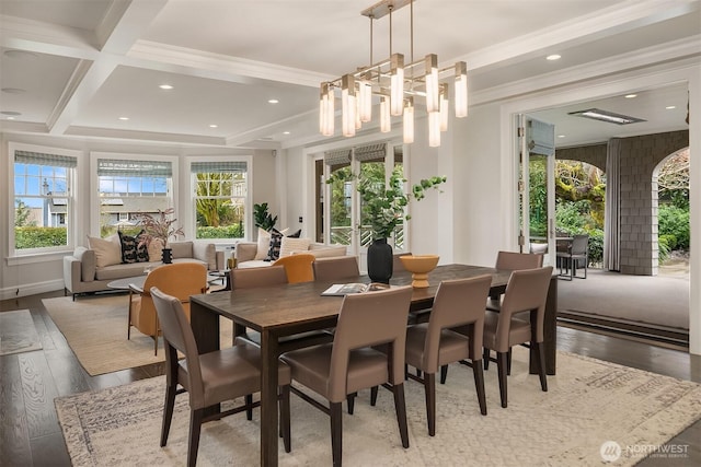 dining space featuring ornamental molding, a wealth of natural light, beamed ceiling, and hardwood / wood-style flooring