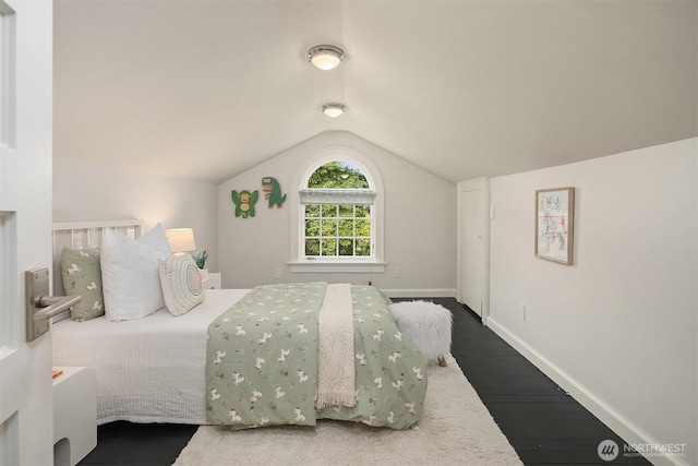 bedroom featuring lofted ceiling, wood finished floors, and baseboards