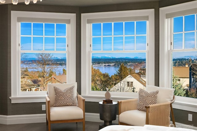 living area featuring a water view and baseboards