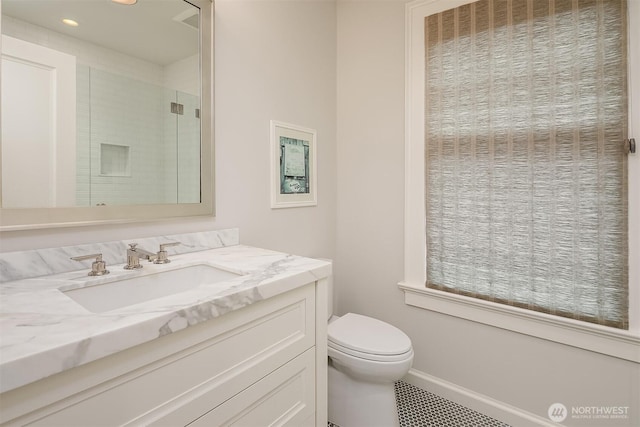 bathroom with toilet, recessed lighting, vanity, baseboards, and a shower stall