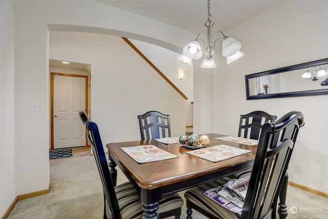 dining space with lofted ceiling, light colored carpet, and a chandelier