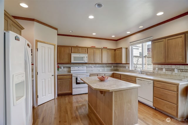 kitchen featuring white appliances, a center island, sink, backsplash, and ornamental molding