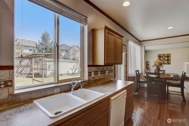 kitchen with dark hardwood / wood-style floors, tasteful backsplash, dishwasher, crown molding, and sink