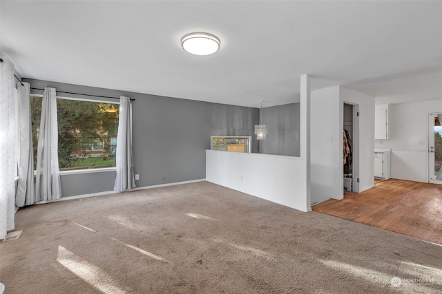 unfurnished living room with carpet floors and an inviting chandelier