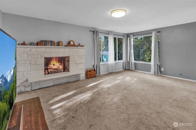 unfurnished living room featuring carpet floors and a stone fireplace