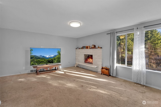 living room featuring carpet and a stone fireplace