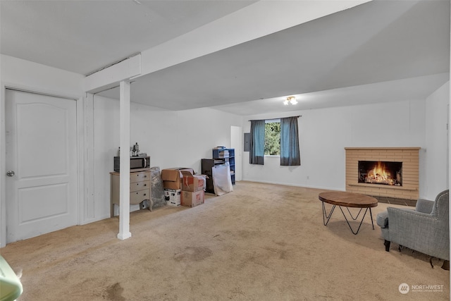 basement featuring a brick fireplace and carpet floors