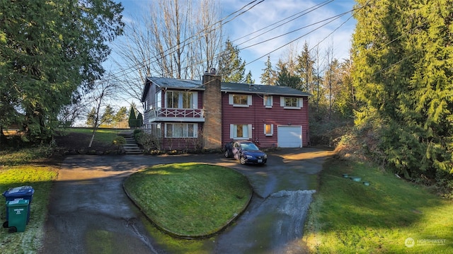 view of front of home with a front lawn, a balcony, and a garage