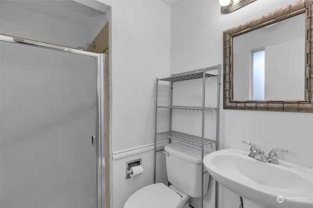 bathroom with sink, an enclosed shower, and toilet