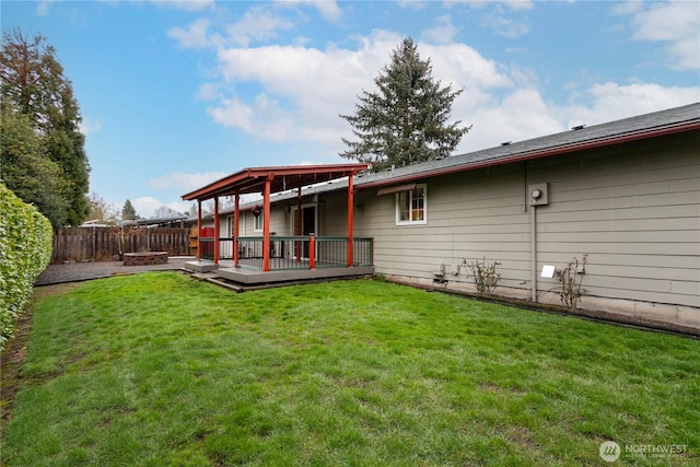 back of property featuring a yard, a fenced backyard, and a wooden deck