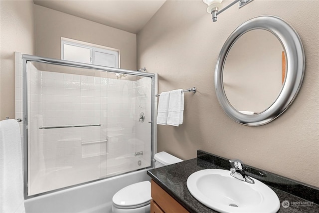 full bathroom featuring toilet, vanity, and shower / bath combination with glass door