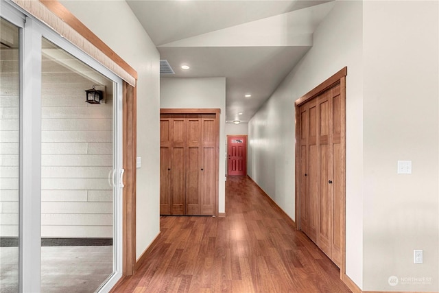 hallway featuring hardwood / wood-style flooring and lofted ceiling