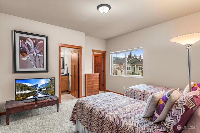 bedroom featuring light carpet and connected bathroom