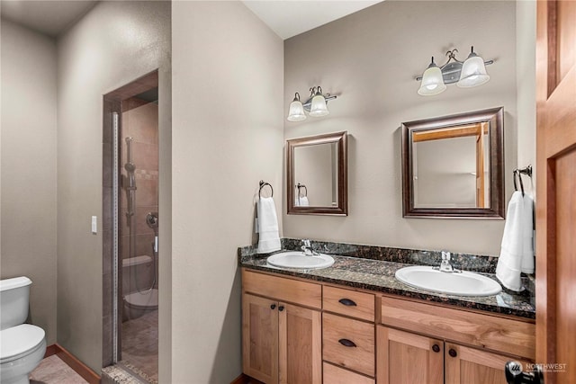 bathroom featuring toilet, vanity, and a tile shower