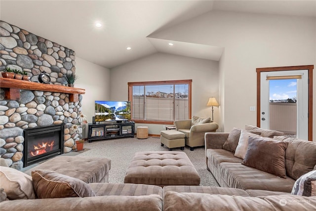 carpeted living room featuring a stone fireplace and vaulted ceiling