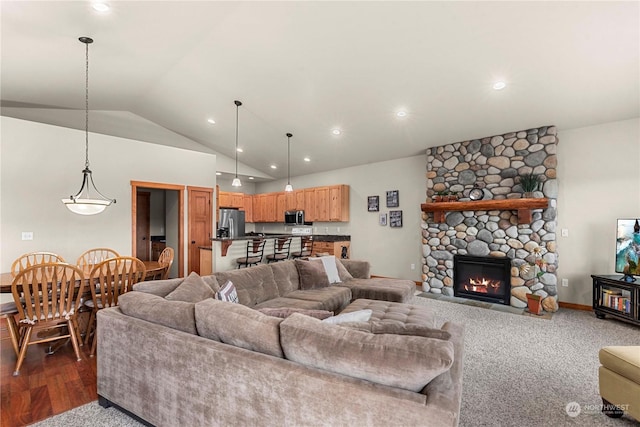 living room with lofted ceiling, dark hardwood / wood-style floors, and a stone fireplace