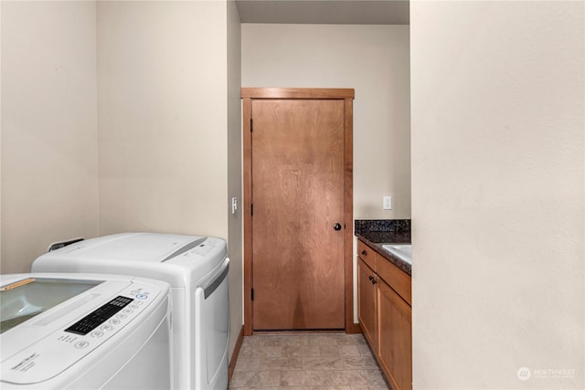 laundry room featuring cabinets, sink, and washing machine and clothes dryer