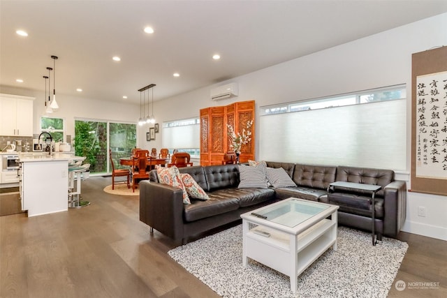 living room featuring sink, hardwood / wood-style flooring, and an AC wall unit