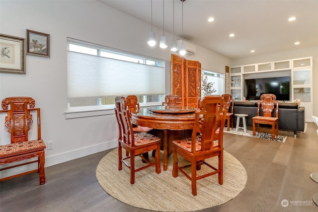 dining area with dark wood-type flooring and a wall mounted AC