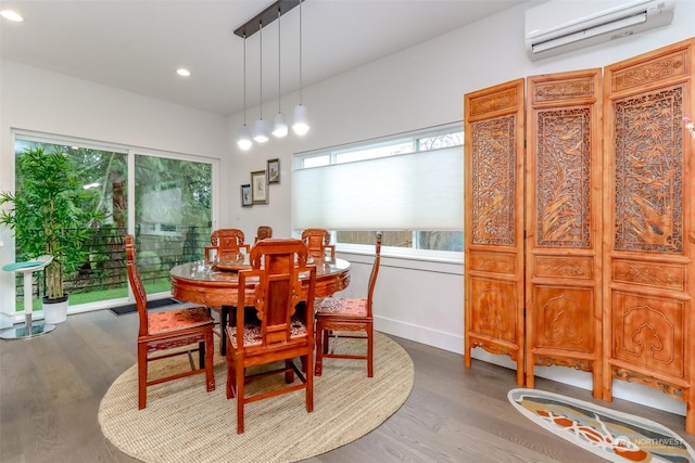 dining area with a wall mounted air conditioner and hardwood / wood-style floors