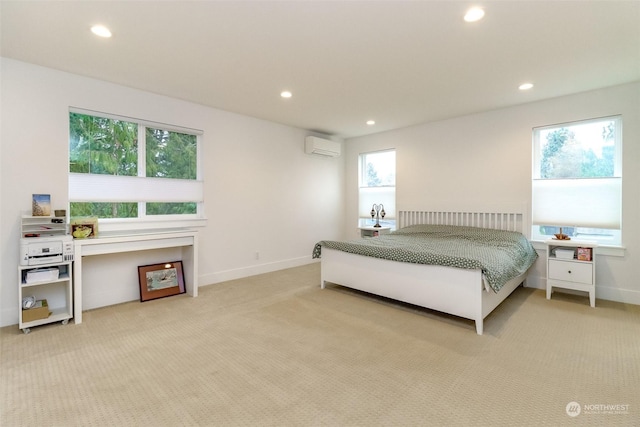 bedroom with an AC wall unit and light carpet