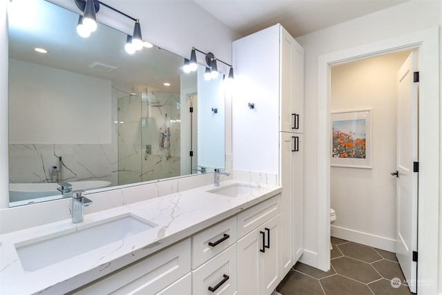 bathroom with toilet, tile patterned flooring, walk in shower, and vanity